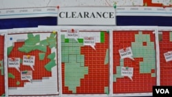 FILE - Maps indicating the progress of UXO technical surveys and clearance operations are displayed in Phonsavan, Laos, Nov. 1, 2019. (Zsombor Peter/VOA)