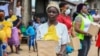 Seorang perempuan menerima bantuan makanan dari relawan saat lockdown atau karantina wilayah untuk mencegah penularan virus corona (COVID-19), di Lagos, Nigeria, 9 April 2020.