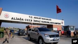 Turkish soldiers stand guard as a car carrying American Pastor Andrew Brunson leaves the courthouse after his release following his trial in Izmir, Turkey, Oct. 12, 2018.