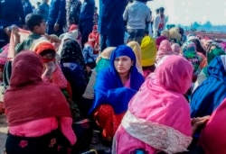 Rohingya refugees wait after their boat capsized, in Teknaf, near Cox's Bazar, Bangladesh, Feb. 11, 2020.