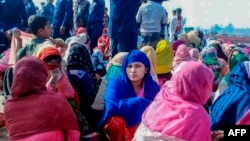 FILE - Rohingya refugees wait in an area following a boat capsizing accident, in Teknaf, Febr. 11, 2020.