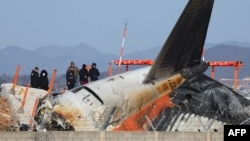 Penyidik ​​dari Korea Selatan dan AS memeriksa lokasi jatuhnya pesawat Boeing 737-800 Jeju Air yang terbakar di Bandara Internasional Muan, di Muan, Korea Selatan, 31 Desember 2024. (Foto: AFP)