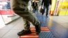 FILE - A man steps on a doormat depicting a U.S. flag, inside a shopping center in Moscow, Russia, Dec. 25, 2014.