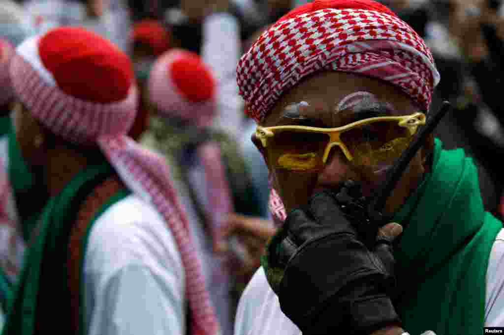 Seorang pendemo menggunakan walkie-talkie dalam unjuk rasa dekat kantor Badan Pengawas Pemilu di Jakarta, 22 Mei 2019. (Foto: Reuters/Willy Kurniawan)