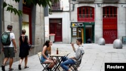 Una pareja conversa en la sección exterior de un bar en Madrid, España, el 28 de julio de 2020.