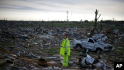 A volunteer stands in a destroyed neighborhood in Joplin, Missouri on May 27, 2011.