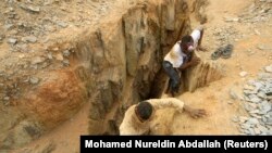 FILE - Gold mine workers climb out from a local mine in Sudan, July 30, 2013. Authorities reported a gold mine collapse March 31, 2023, near the Egyptian border that left 14 workers dead and many others injured.