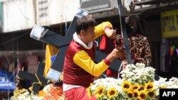 FILE - A Catholic devotee fixes a replica of the Black Nazarene during the blessing of replicas in front of the Quiapo church in Manila on January 4, 2024, ahead of the annual religious procession on January 9.