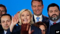 FILE - French far right leader Marine Le Pen, center, waves on stage next to other populist leaders at the end of a May Day meeting in Nice, south of France, May 1, 2018.