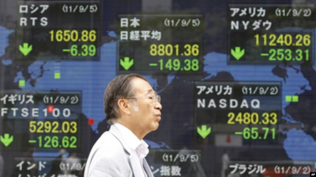 A man walks by an electronic stock board of a securities firm in Tokyo, September 5, 2011.