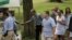 U.S. President Barack Obama, center, shakes hands with a vendor while walking in Central Park with daughters Sasha, second from right, and Malia, right, in New York, July 18, 2015. 