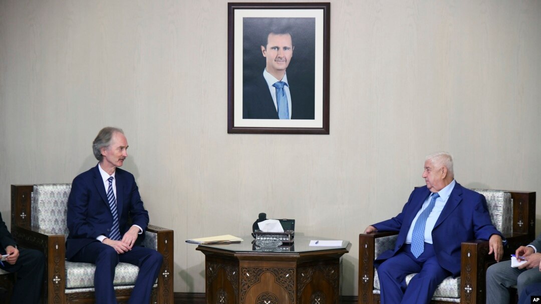 FILE - In this photo released by the Syrian official news agency SANA, the U.N.'s special envoy for Syria Geir Pedersen, left, meets with Syrian Foreign Minister Walid al-Moallem, in Damascus, Syria, Sept. 23, 2019. 