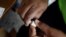 FILE - A member of the vaccination campaign against cholera opens a vial at the Immaculate Conception Hospital in Les Cayes, Haiti, Nov. 8, 2016. 