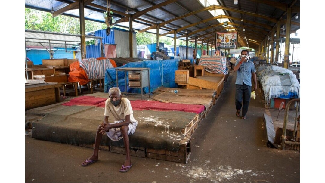 FILE - A Sri Lankan man rests in a vegetable market closed to curb the spread of the coronavirus in Colombo, Sri Lanka, June 16, 2021.