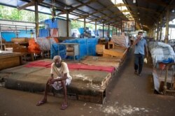 FILE - A Sri Lankan man rests in a vegetable market closed to curb the spread of the coronavirus in Colombo, Sri Lanka, June 16, 2021.