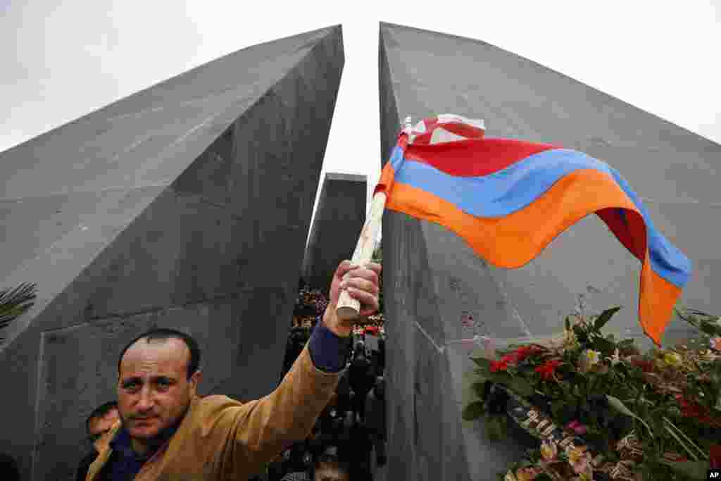 A man waves Armenian and Georgian flags at a memorial to Armenians killed by the Ottoman Turks, during marking the centenary of the mass killings, in Yerevan, Armenia, April 24, 2015. 