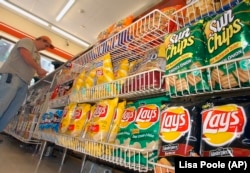 FILE - A customer makes a purchase at a convenience store in Boston in this July 12, 2005 file photo. (AP Photo/Lisa Poole, file)