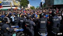 ARCHIVO - Manifestantes opositores bloquean el paso de policías venezolanos en Caracas, el 9 de enero de 2025. Según la ONG Foro Penal, el número de arrestos por razones políticas este mes se elevó a 83.