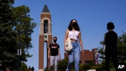 Mahasiswa bertopeng berjalan menyusuri kampus Ball State University di Muncie, Kamis, 10 September 2020. (Foto: AP)