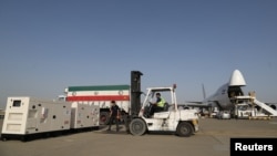 Seorang petugas kargo tampak bekerja memuat sejumlah muatan di Bandara Mehrabad di barat Teheran, Iran, pada 5 Agustus 2020. (Foto: WANA (West Asia News agency) via Reuters)