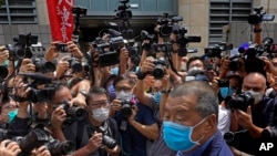 FILE - Hong Kong media tycoon Jimmy Lai, lower right, arrives at court for charges relating to unlawful protests from last year in Hong Kong, May 18, 2020.