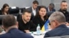 Ukrainian President Volodymyr Zelenskyy, center left, listens while visiting the Scranton Army Ammunition Plant in Scranton, Pennsylvania, Sept. 22, 2024. Seated next to Zelenskyy is Ukraine's Ambassador to the U.S. Oksana Markarova. (Sgt. 1st Class Curt Loter/U.S. Army via AP)