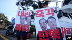 Los manifestantes sostienen pancartas que muestran imágenes del presidente acusado Yoon Suk Yeol (derecha) y del presidente en funciones Han Duck-soo durante una manifestación en Seúl, Corea del Sur, el 27 de diciembre de 2024. Los carteles dicen "Acusación inmediata". AP