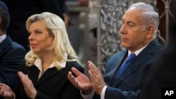 FILE - Israeli Prime Minister Benjamin Netanyahu, right, and his wife Sara Netanyahu applaud during their visit to a synagogue in Vilnius, Lithuania, Aug. 26, 2018.