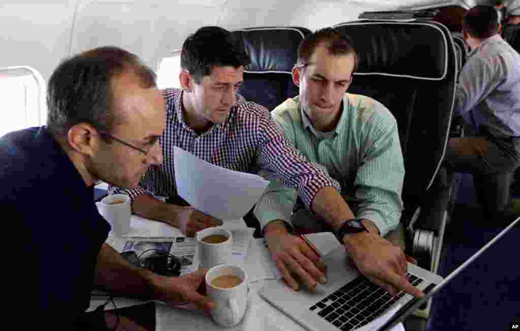 Kandidat wakil presiden Paul Ryan (tengah) menyusun pidato yang akan disampaikan pada konvensi bersama penasihat senior Dan Senor (kiri) dan staf senior Conor Sweeney.