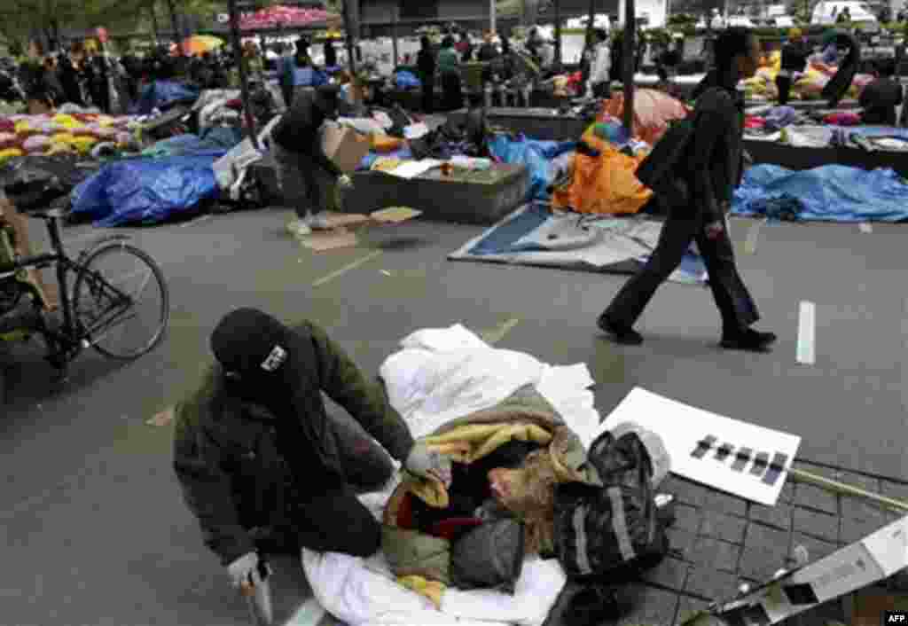 A woman talks to a friend after sleeping in Zuccotti Park in the financial district in New York, Tuesday, Oct. 4, 2011. The protests have gathered momentum and gained participants in recent days as news of mass arrests and a coordinated media campaign by 