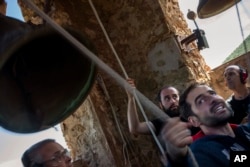 Students of the Vall d'en Bas School of Bell Ringers, demonstrate their skill at the 12th-century Sant Romà church in the tiny Spanish village village of Joanetes, June 29, 2024. (AP Photo/Emilio Morenatti)