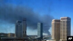 Smoke rises over the western side of Tripoli, October 14, 2011