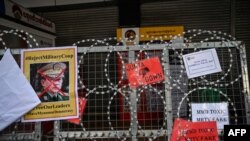 Berbagai poster penolakan Jenderal militer Myanmar, Min Aung Hlaing tampak dipasang di kawat berduri di tengah demo antikudeta di Yangon, 22 Februari 2021. (Foto: Ye Aung THU/AFP)