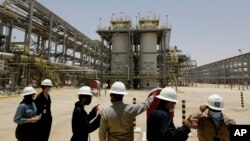 FILE - Saudi Aramco engineers and journalists look at the Hawiyah Natural Gas Liquids Recovery Plant, June 28, 2021, in Hawiyah, in the Eastern Province of Saudi Arabia.