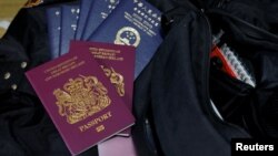 Paspor Warga Negara Inggris di Luar Negeri atau British National Passport dan paspor Wilayah Administratif Khusus Hong Kong, Republik Rakyat China, di tas seorang warga Hong Kong, 17 Desember 2020. (Foto: Tyrone Siu/Reuters)