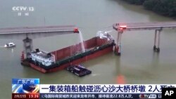 In this image from video released by China's CCTV, people inspect the broken Lixinsha Bridge after it was hit by a container ship in Nansha District of Guangzhou, southern China's Guangdong province, on Feb. 22, 2024. Five people died in the incident.