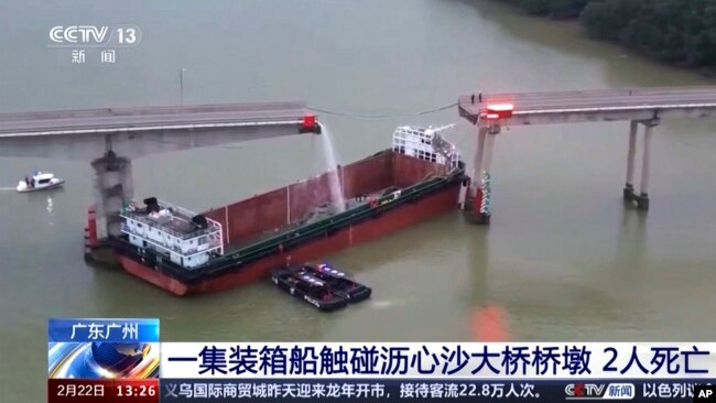 In this image from video released by China's CCTV, people inspect the broken Lixinsha Bridge after it was hit by a container ship in Nansha District of Guangzhou, southern China's Guangdong province, on Feb. 22, 2024. Five people died in the incident.