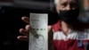 Un hombre muestra un nuevo billete de 200.000 bolívares - la moneda oficial - después de retirarlo de un banco en Caracas, el 16 de marzo de 2021.