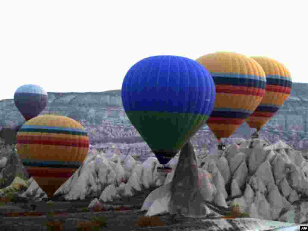 In this Nov. 15, 2010 photo, hot air balloons rise to the sky at sunrise in Cappadocia, central Turkey. Formed by gas bubbling through ash, Cappadocia has become a favorite site for tourists in hot-air balloons who can slowly drift above the "fairy chimne