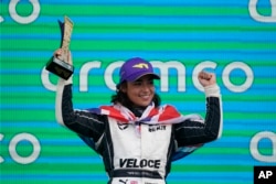 Jamie Chadwick, memegang trofi setelah memenangkan balapan mobil Seri W di Circuit of the Americas, di Austin, Texas, Minggu, 24 Oktober 2021. (Darron Cummings/AP)