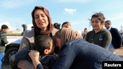 FILE - Relatives hug a Yazidi survivor following the boy's release from Islamic State militants in Syria, in Duhok, Iraq, March 2, 2019.