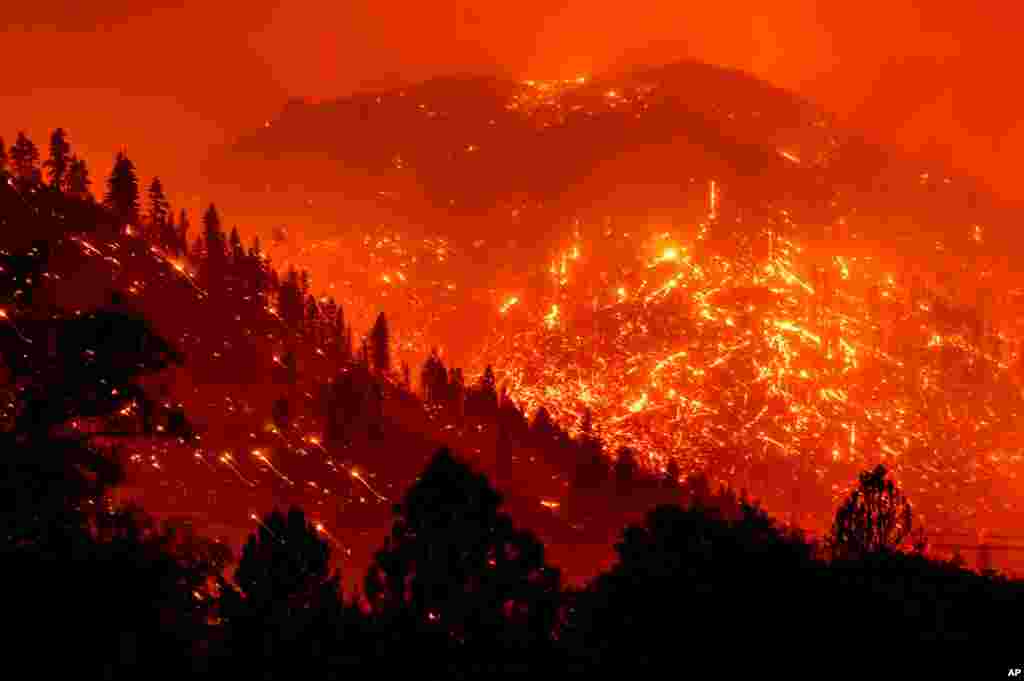 Seen in a long exposure photograph, embers light up hillsides as the Dixie Fire burns near Milford in Lassen County, California, Aug. 17, 2021.