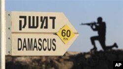 Sign showing distances to Damascus and a cut out of a soldier are seen at an army post from the 1967 war at Mt. Bental, Golan Heights, July 24, 2012.