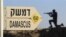 Sign showing distances to Damascus and a cut out of a soldier are seen at an army post from the 1967 war at Mt. Bental, Golan Heights, July 24, 2012.