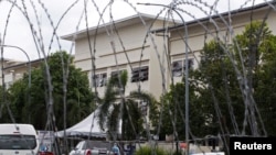 FILE - Exterior of workers' hostel for Top Glove, the world's largest glove maker, is seen through barricade amid the COVID-19 outbreak in Meru, Selangor state, Malaysia, Nov. 24, 2020.