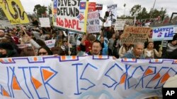 FILE - Protesters rally against the Dakota Access Pipeline behind the 128th Rose Parade in Pasadena, Calif., Jan. 2, 2017. The front lines of the battle against the $3.8 billion Dakota Access pipeline are shifting away from the dwindling encampment in North Dakota.