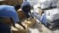 Workers unload emergency aid from a UNHCR-chartered aircraft in Mogadishu, August 8, 2011. 