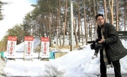 FILE - VOA's Steve Herman records video on the perimeter of the 20km radiation exclusion zone in Fukushima prefecture, Kawauchi, Japan.
