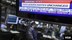 Una pantalla en la Bolsa de Nueva York muestra la decisión de la FED de dejar invariable la tasa de interés.