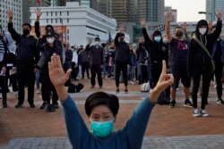 FILE - Protesters raise five demands gestures during a rally in Hong Kong, Jan. 12, 2020.